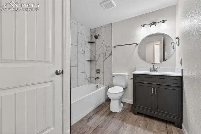 a bathroom with a toilet sink double vanity and bathtub