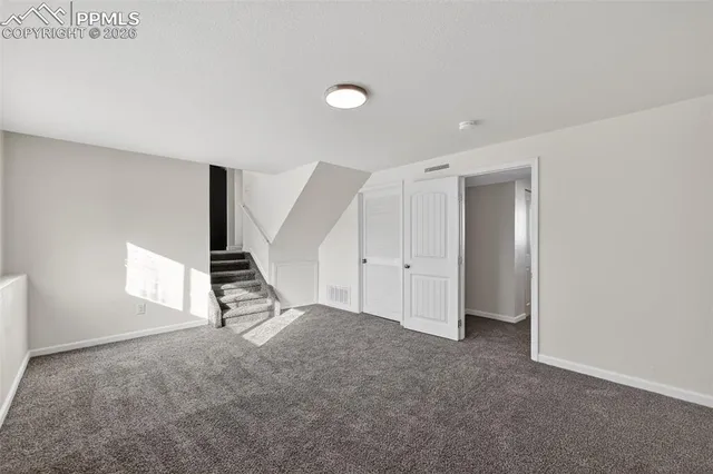 an empty room with windows and stairs