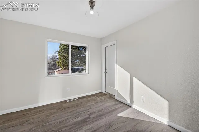 wooden floor in an empty room with a window