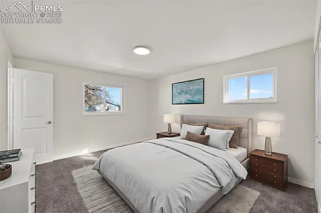 a bedroom with a large bed and a lamp