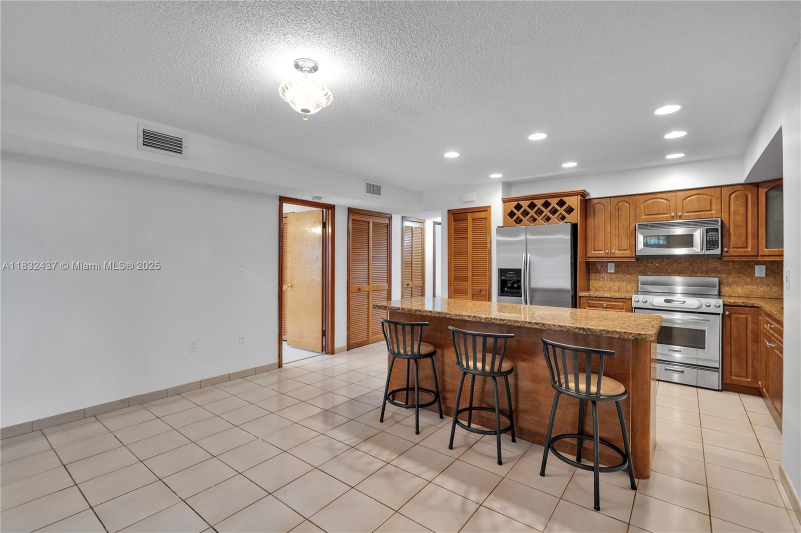 7811 Southwest 9th Terrace Miami, FL 33144 - Photo 2 of 27 a kitchen with stainless steel appliances a table and chairs in it