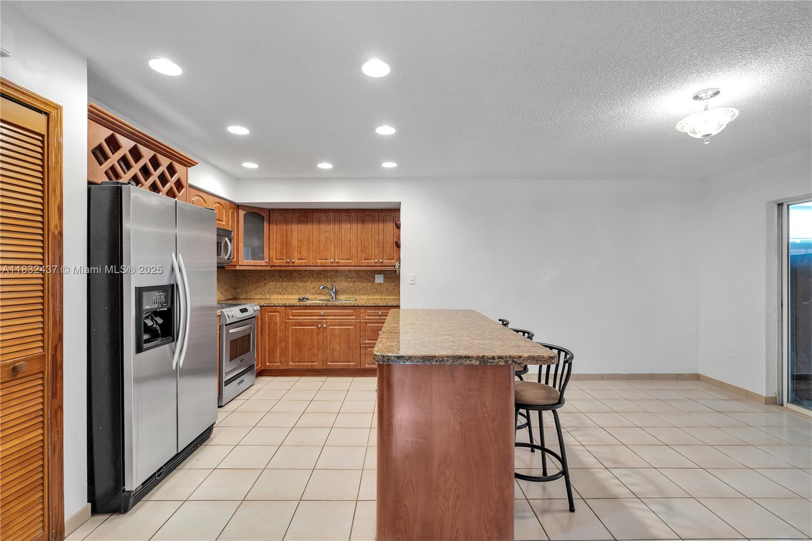 7811 Southwest 9th Terrace Miami, FL 33144 - Photo 8 of 27 a kitchen with stainless steel appliances kitchen island granite countertop a refrigerator and a stove top oven