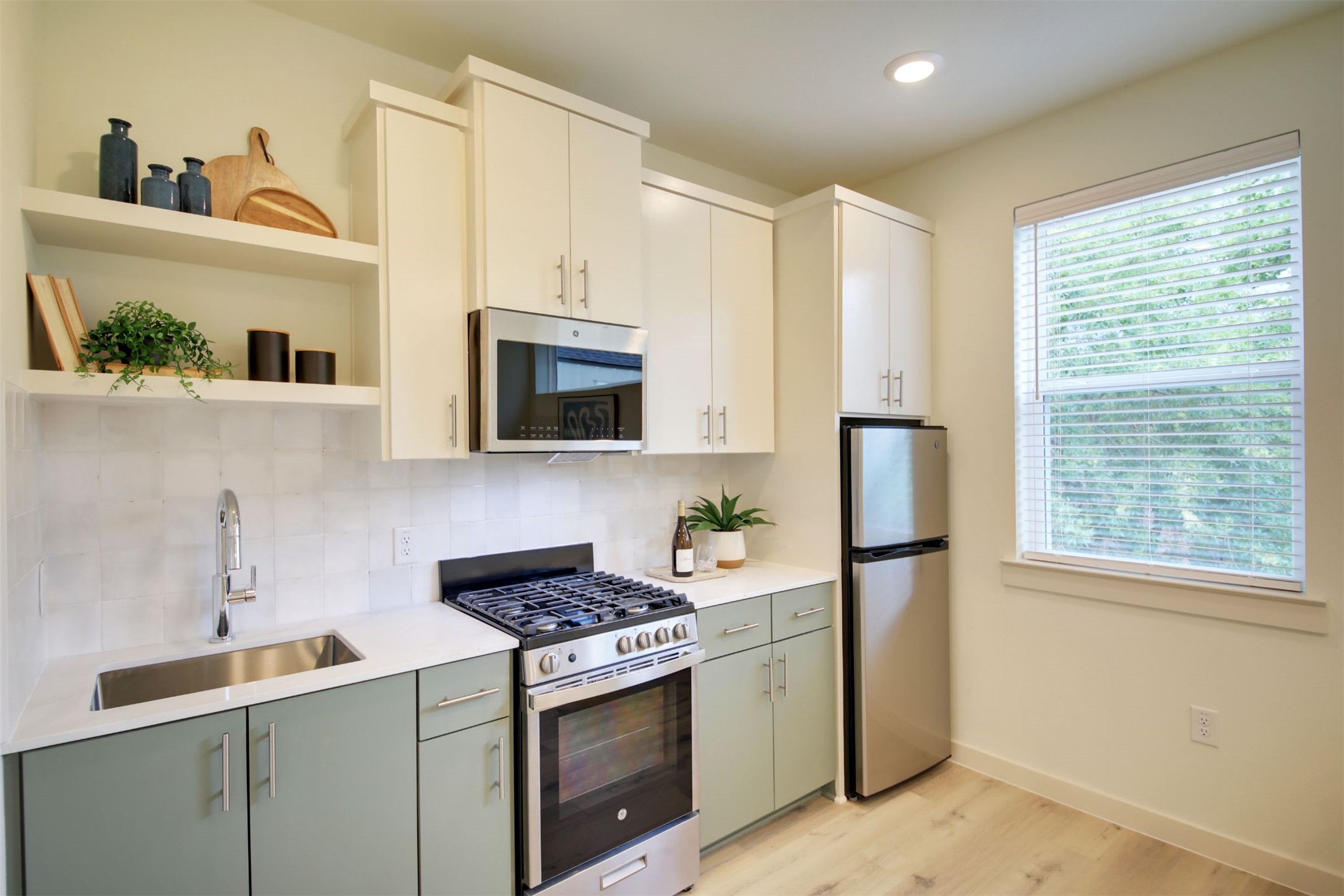 6802 Montana Street, Unit 2 Austin, TX 78741 - Photo 6 of 13 A compact kitchen with sleek appliances and open shelving for modern living.