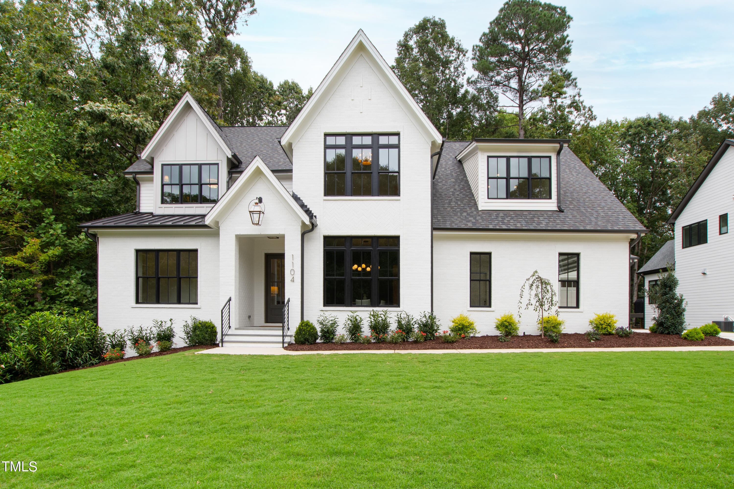 1104 Manchester Drive Raleigh, NC 27609 - Photo 1 of 52 a front view of a house with a garden and trees