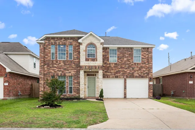 a front view of a house with a garden and plants