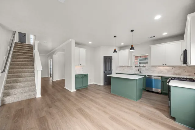 a large kitchen with cabinets and wooden floor