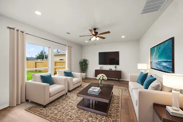 a living room with furniture a flat screen tv and a large window