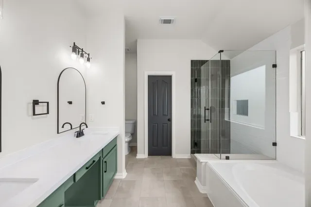 a spacious bathroom with a double vanity sink mirror and shower