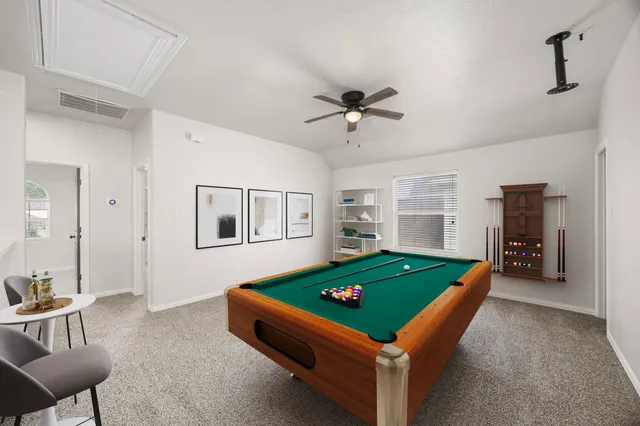a room with furniture pool table and window