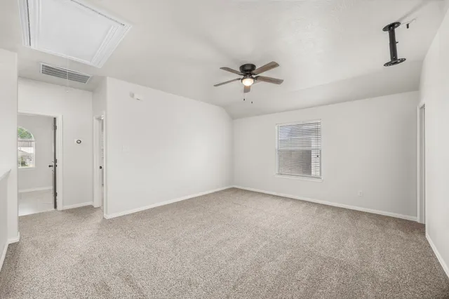 a view of room with a ceiling fan and entryway