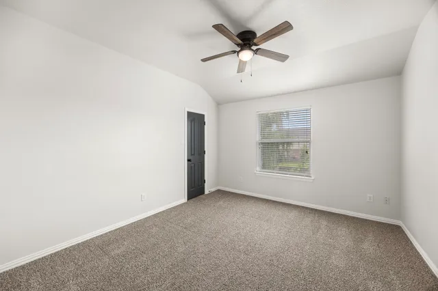 an empty room with a ceiling fan and a window
