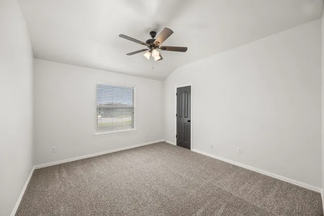a view of a room with a ceiling fan and window
