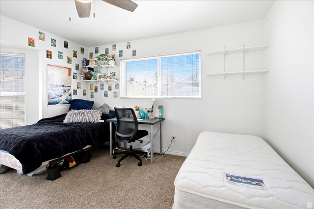 992 900 East, Unit 29 Provo, UT 84604 - Photo 9 of 18 Carpeted room featuring multiple windows with horizontal blinds, built-in wall shelving, and a ceiling fan
