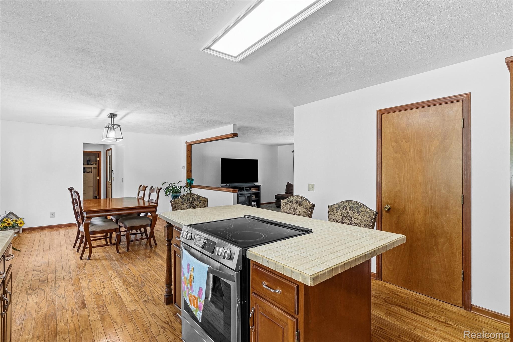 6699 Lansing Road Durand, MI 48429 - Photo 15 of 53 Kitchen island with a tiled countertop and integrated electric range