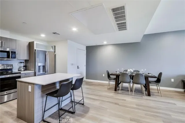 a large kitchen with kitchen island granite countertop white cabinets and stainless steel appliances