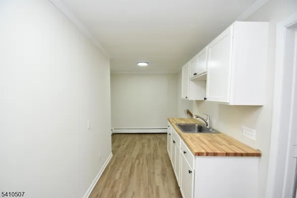a kitchen with a sink and wooden floor