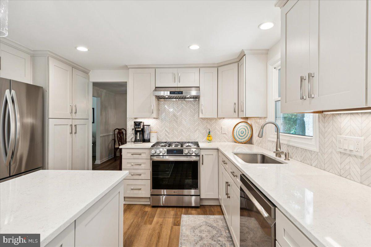 1377 Rock Chapel Road Herndon, VA 20170 - Photo 12 of 65 a kitchen with a sink a stove a refrigerator and white cabinets