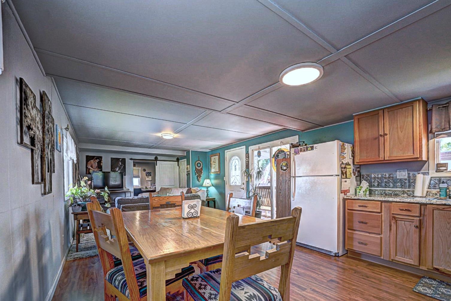 585-25 25 1/2 Road, Unit 72 Grand Junction, CO 81505 - Photo 16 of 21 a dining room with stainless steel appliances granite countertop a refrigerator a sink dishwasher a dining table and chairs with wooden floor