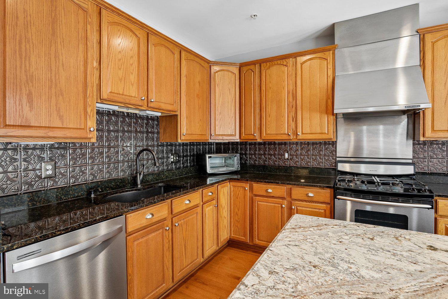 2396 Jostaberry Way Odenton, MD 21113 - Photo 14 of 55 a kitchen with stainless steel appliances a sink stove and cabinets