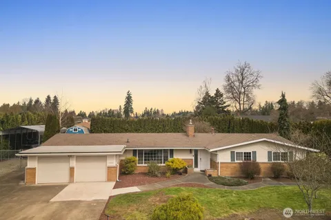 a front view of a house with a yard and lake view