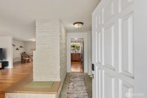 a view of a hallway with wooden floor and windows
