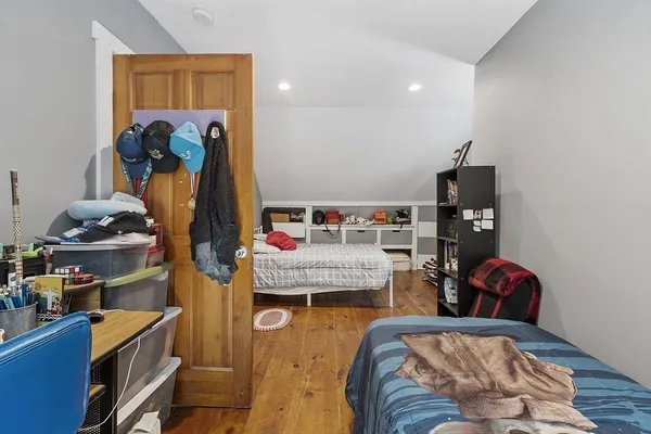 a bedroom with a bed a dresser and a book shelf