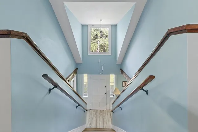 a front view of a house with a garden and trees