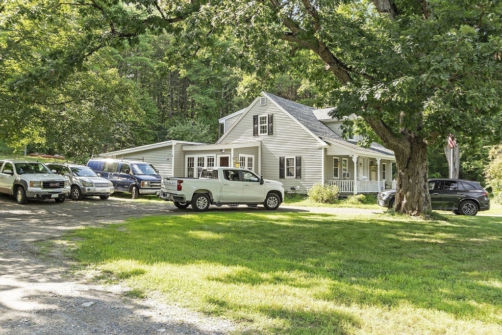 610 South Main Street Orange, MA 01364 - Photo 21 of 38 a front view of a house with a garden and trees
