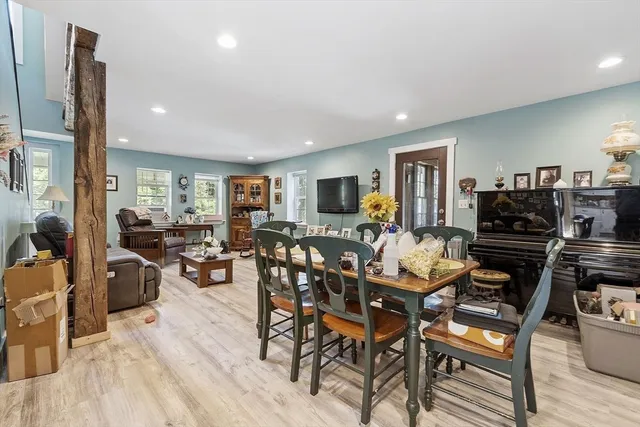a living room with furniture kitchen view and a flat screen tv