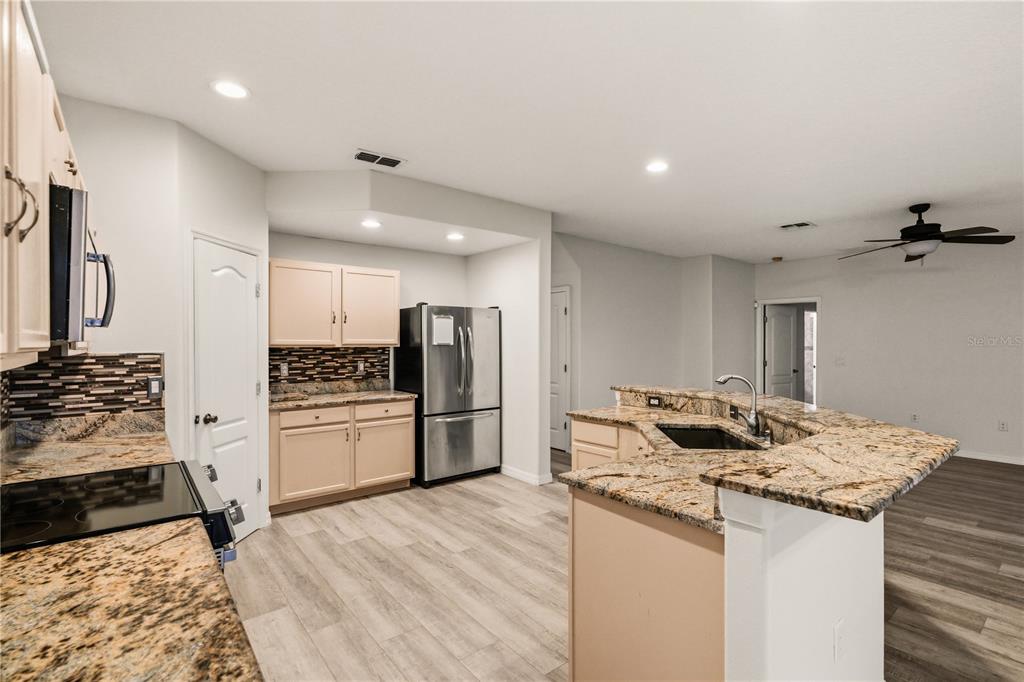 19214 Briercrest Trail Orlando, FL 32833 - Photo 23 of 47 a kitchen with granite countertop a sink stove and refrigerator