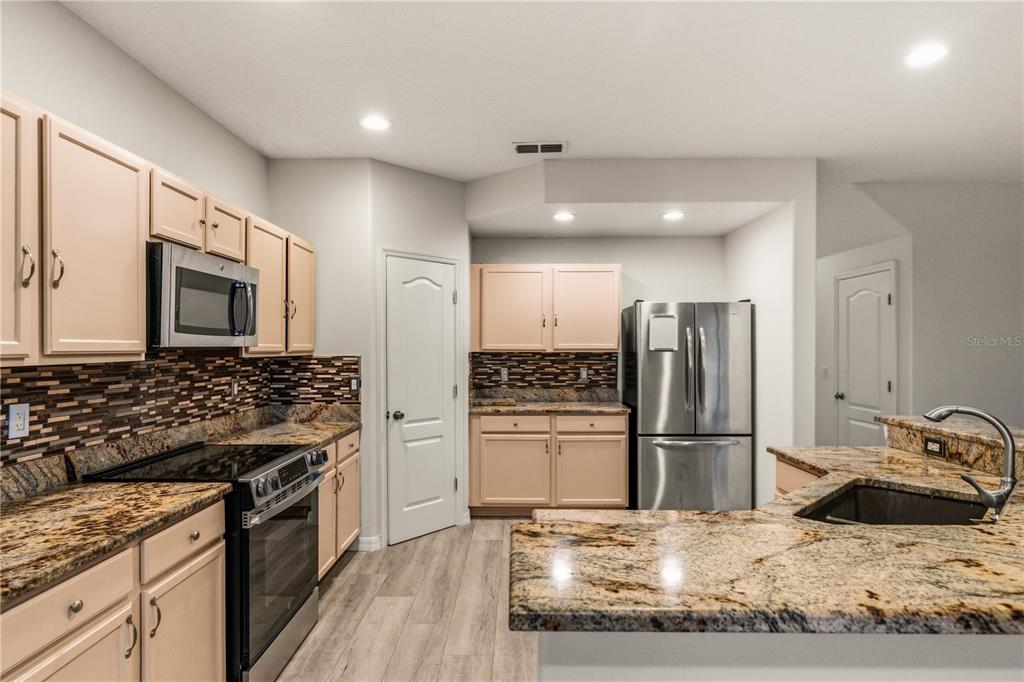 19214 Briercrest Trail Orlando, FL 32833 - Photo 5 of 47 a kitchen with kitchen island granite countertop a refrigerator stove and oven