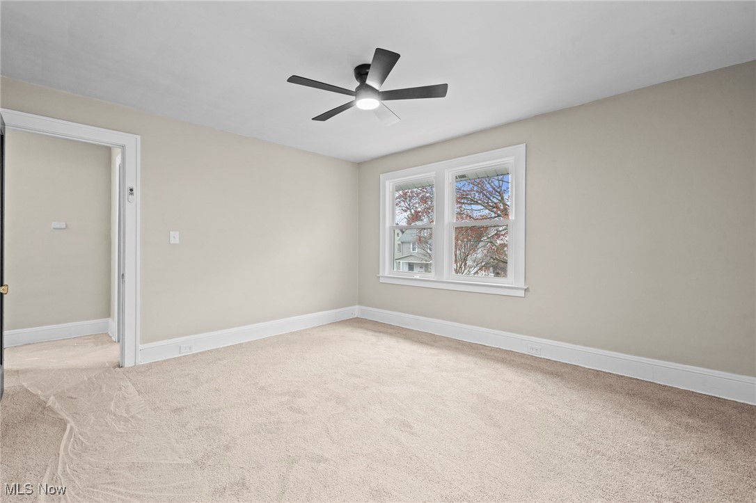 1056 Quilliams Road Cleveland, OH 44121 - Photo 16 of 37 Unfurnished room with light colored carpet and ceiling fan