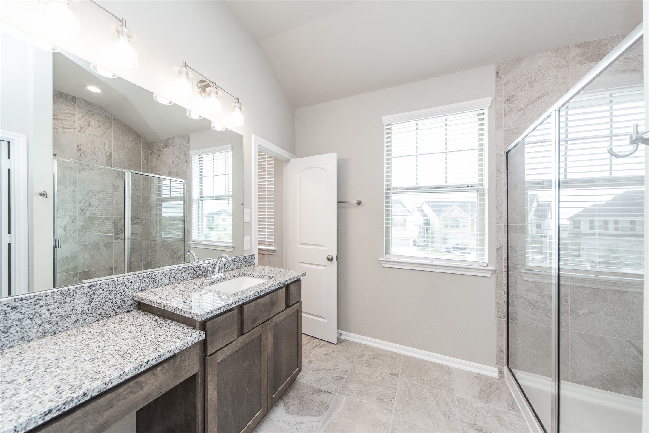 5131 Prairie Terrace Lane Fulshear, TX 77441 - Photo 14 of 21 a bathroom with a granite countertop sink a large mirror and a shower