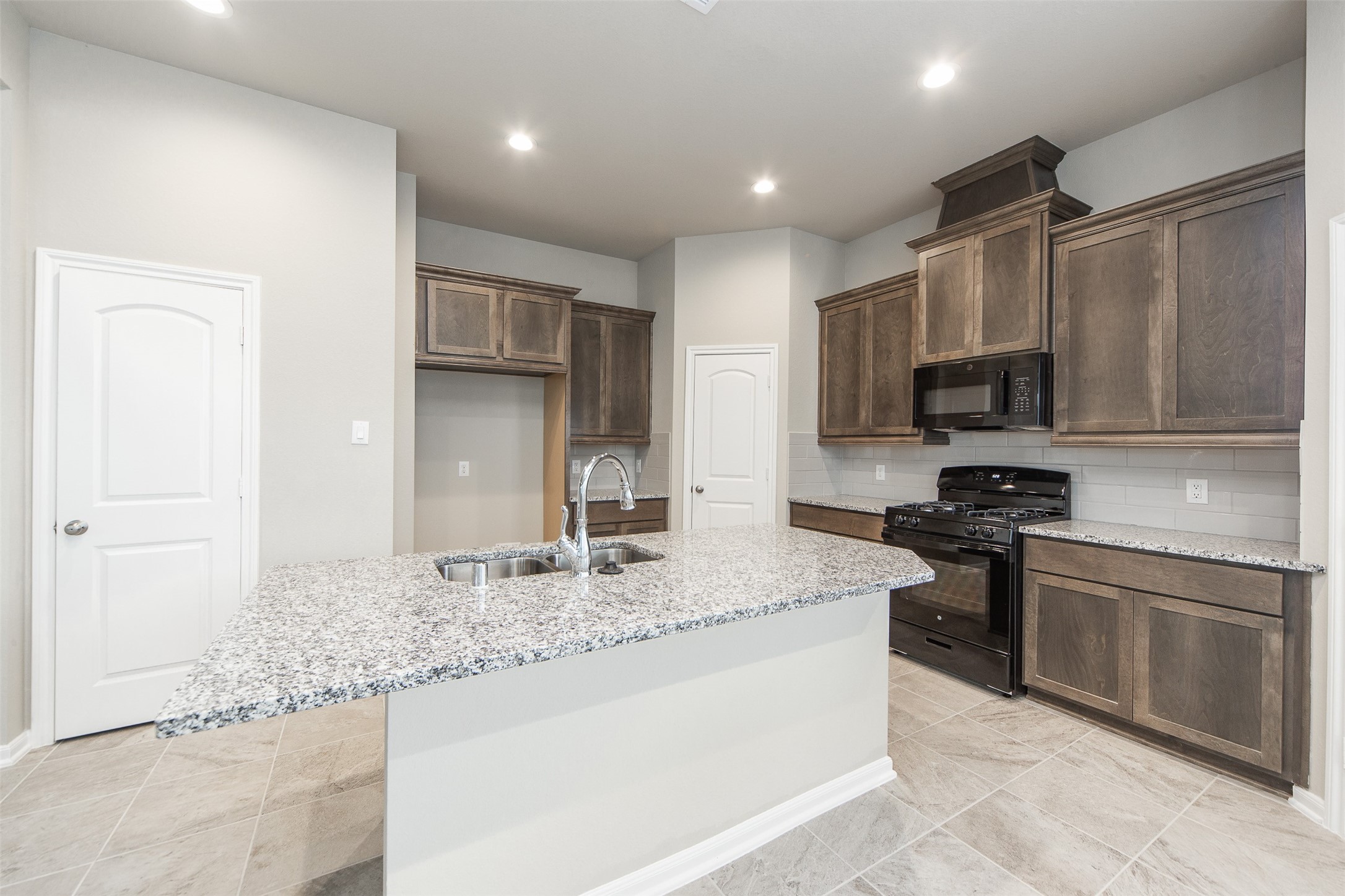 5131 Prairie Terrace Lane Fulshear, TX 77441 - Photo 7 of 21 a kitchen with stainless steel appliances granite countertop a sink stove microwave and refrigerator