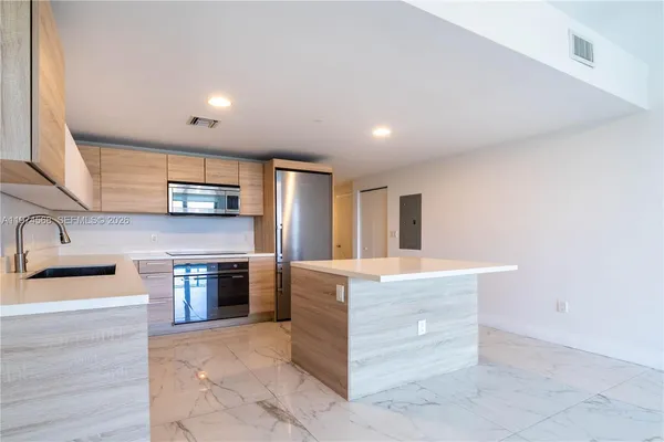 a kitchen with stainless steel appliances granite countertop a sink and a microwave