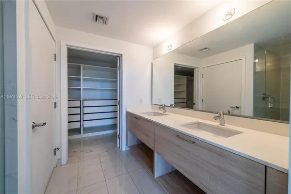 a bathroom with a double vanity sink and a mirror