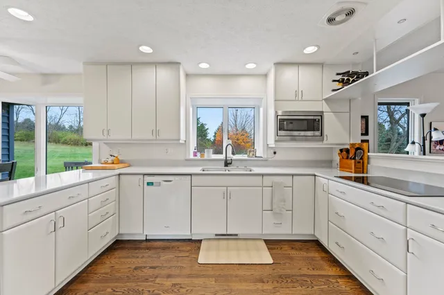 a kitchen with white cabinets and white appliances