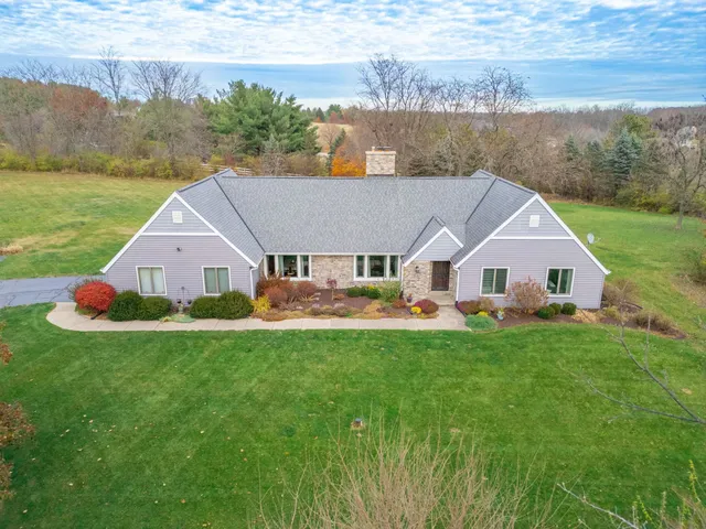 a aerial view of a house with table and chairs next to a yard