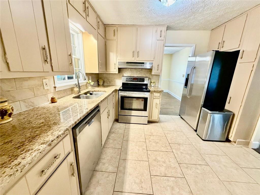 665 Arnold Road Lawrenceville, GA 30044 - Photo 12 of 48 a kitchen with stainless steel appliances granite countertop a sink stove and refrigerator