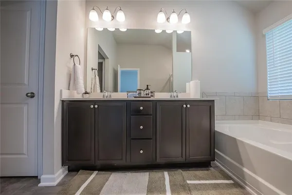 a bathroom with a sink double vanity granite tub and a mirror