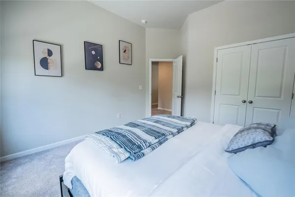 a bedroom with a bed and painting on the wall