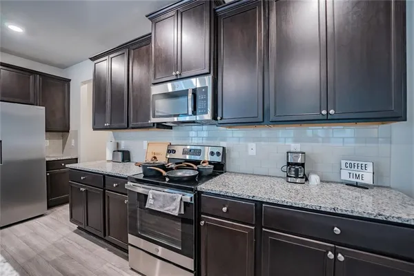 a kitchen with granite countertop stainless steel appliances and wooden cabinets