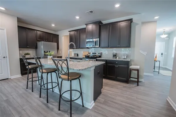 a kitchen with a sink cabinets and wooden floor