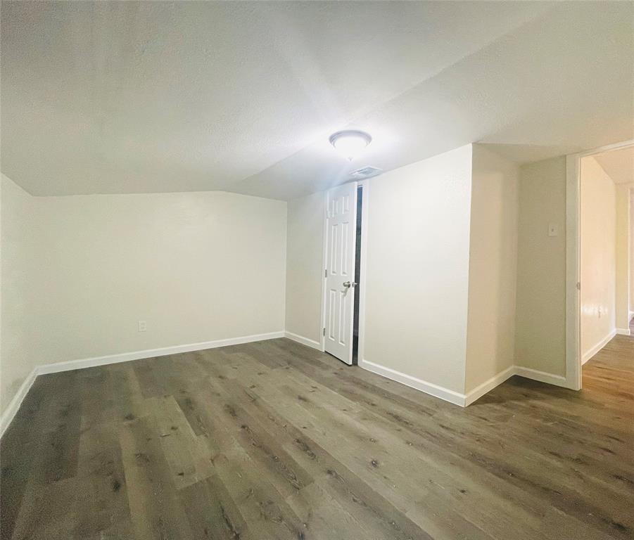 111 Rousseau Street Waxahachie, TX 75165 - Photo 9 of 22 an empty room with wooden floor and windows