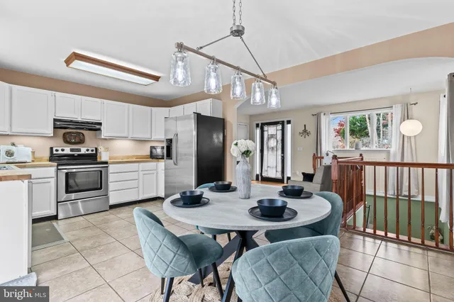a kitchen with refrigerator a sink and chairs