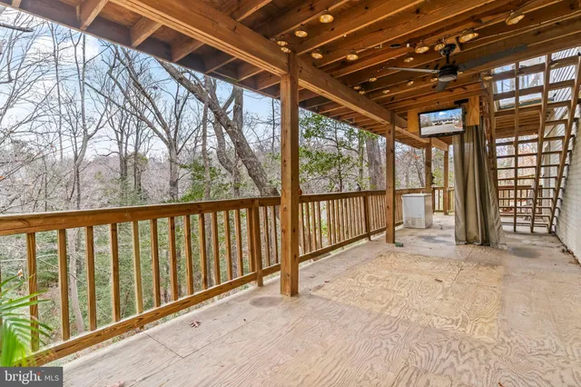 a view of backyard with large trees and wooden fence