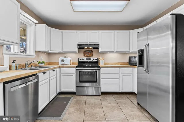 a kitchen with a refrigerator sink and cabinets