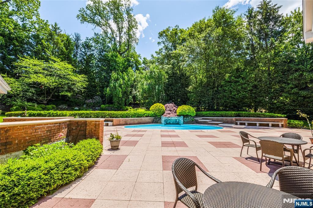 67 Adams Drive Cresskill, NJ 07626 - Photo 36 of 45 a view of a swimming pool with a patio and garden