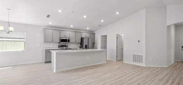 a view of kitchen with stainless steel appliances refrigerator stove top oven and cabinets