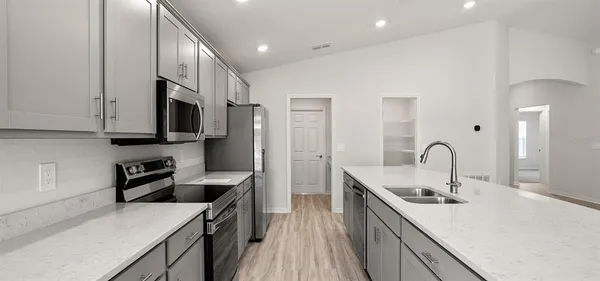 a kitchen with stainless steel appliances granite countertop a sink stove and refrigerator